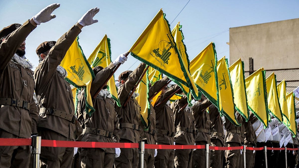 Hezbollah members salute at funeral