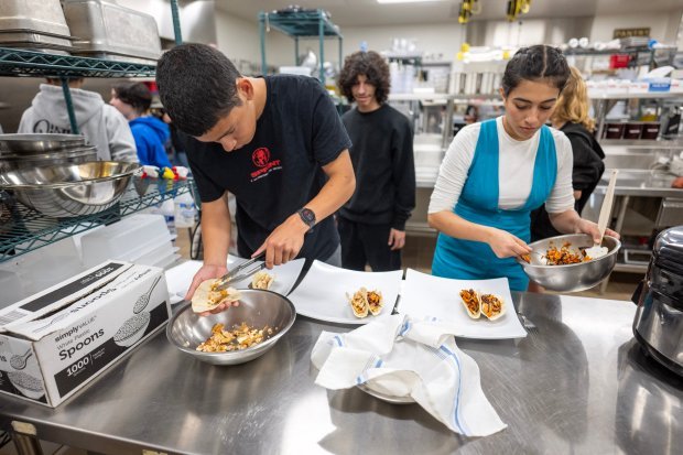 Students Nathan Medina and Ariana Martinez prepare fish tacos during...