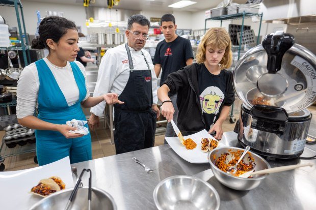 Students Ariana Martinez, Nathan Medina and Venice Weaver work with...