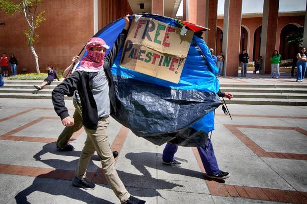 University of Southern California protesters carry a tent around Alumni...