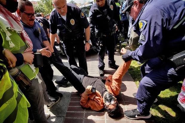 A University of Southern California protester is detained by USC...