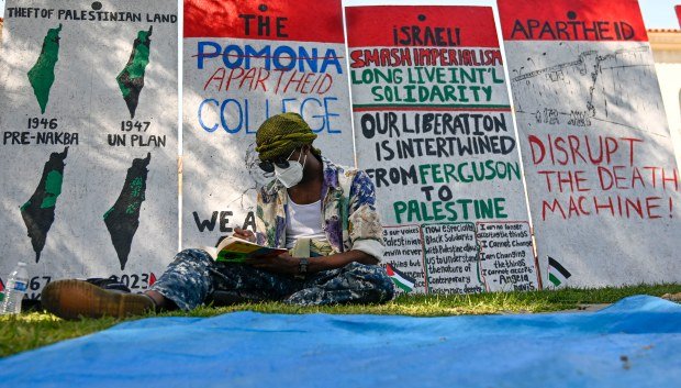 A student protester at Pomona College studies in front of...