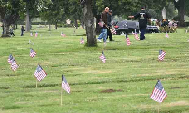 Veterans put flags on veterans grave sites during its 17th...