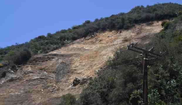 Cal-Trans workers continue cleanup work from a landslide on Friday...