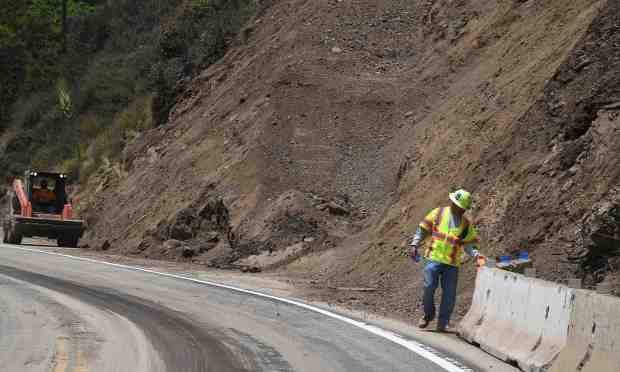 Cal-Trans workers continue cleanup work from a landslide on Friday...
