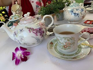 Mismatched tea pots and fresh flowers are part of the...