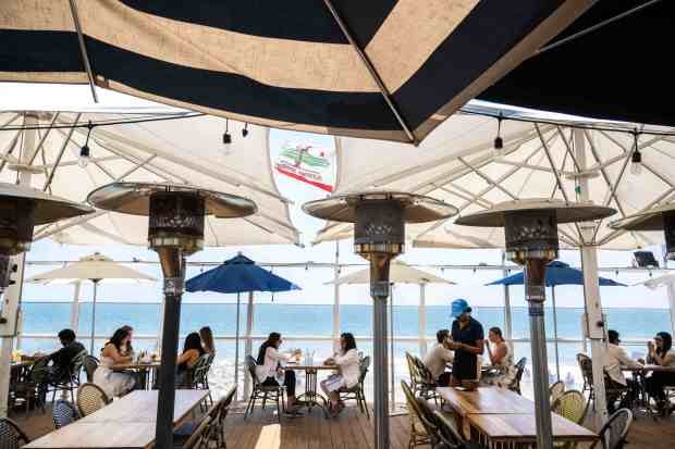 People dine in Gladstones patio overlooking the ocean in Malibu...