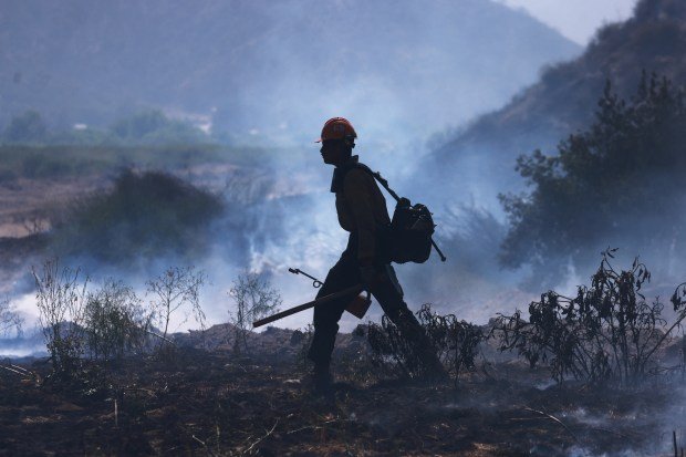 A US Forest Service firefighter sets a controlled burn as...