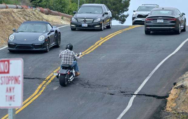 Drivers navigate the rough road along Palos Verdes Drive South...