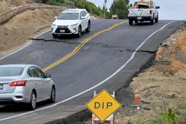 Drivers navigate the rough road along Palos Verdes Drive South...