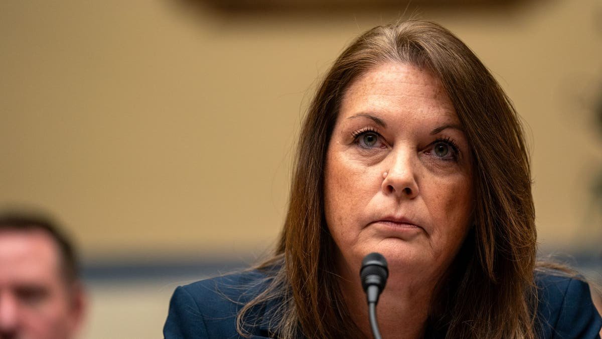 Kimberly Cheatle sits behind a microphone during a congressional hearing