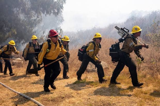 Firefighters from LA City and Angeles National Forest attack a...