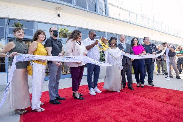 Mayor Rex Richardson, center, cuts a ribbon during the reopening...