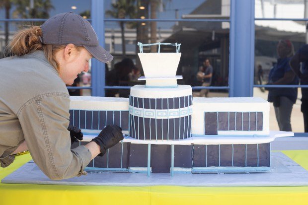 Whitney Crowder adds details to an LGB cake during the...