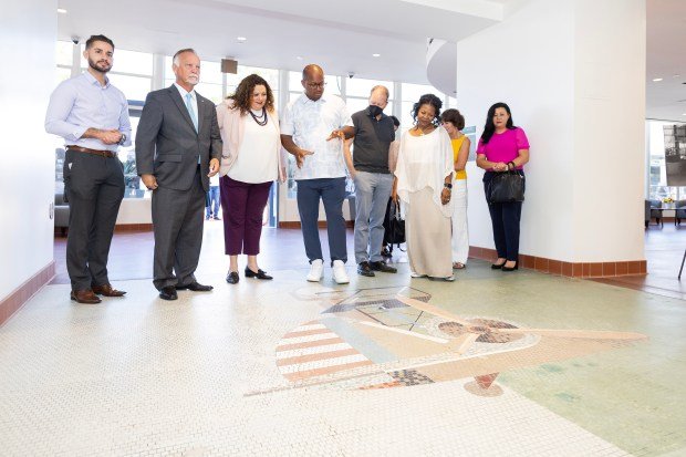 Mayor Rex Richardson, center, describes a mosaic by artist Grace...