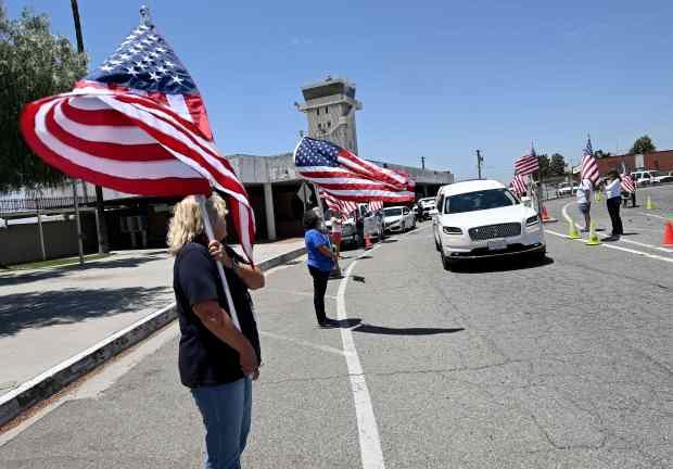 Bob Hope USO volunteers show their respect as the remains...