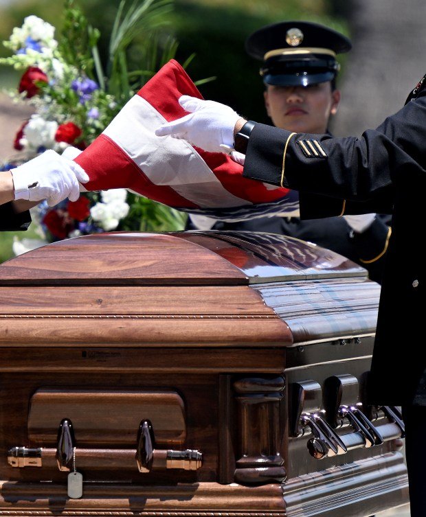 An honor guard detail fold the American flag above the...