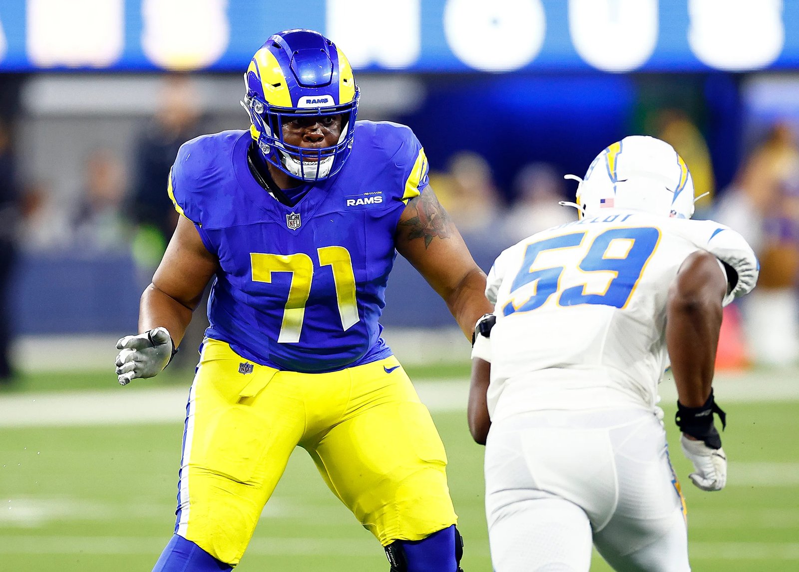 Rams offensive lineman Warren McClendon Jr., left, goes to block...