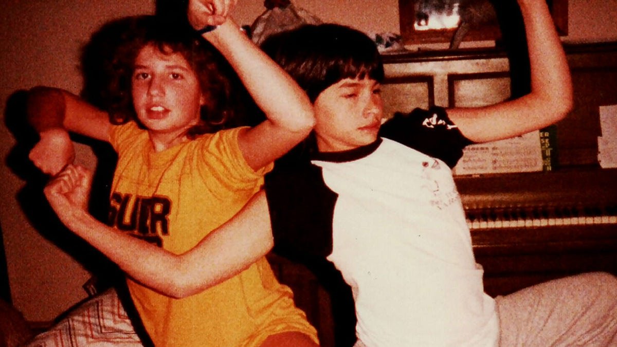 Jonelle Matthews wearing a white and black shirt posing next to her sister wearing a yellow shirt,