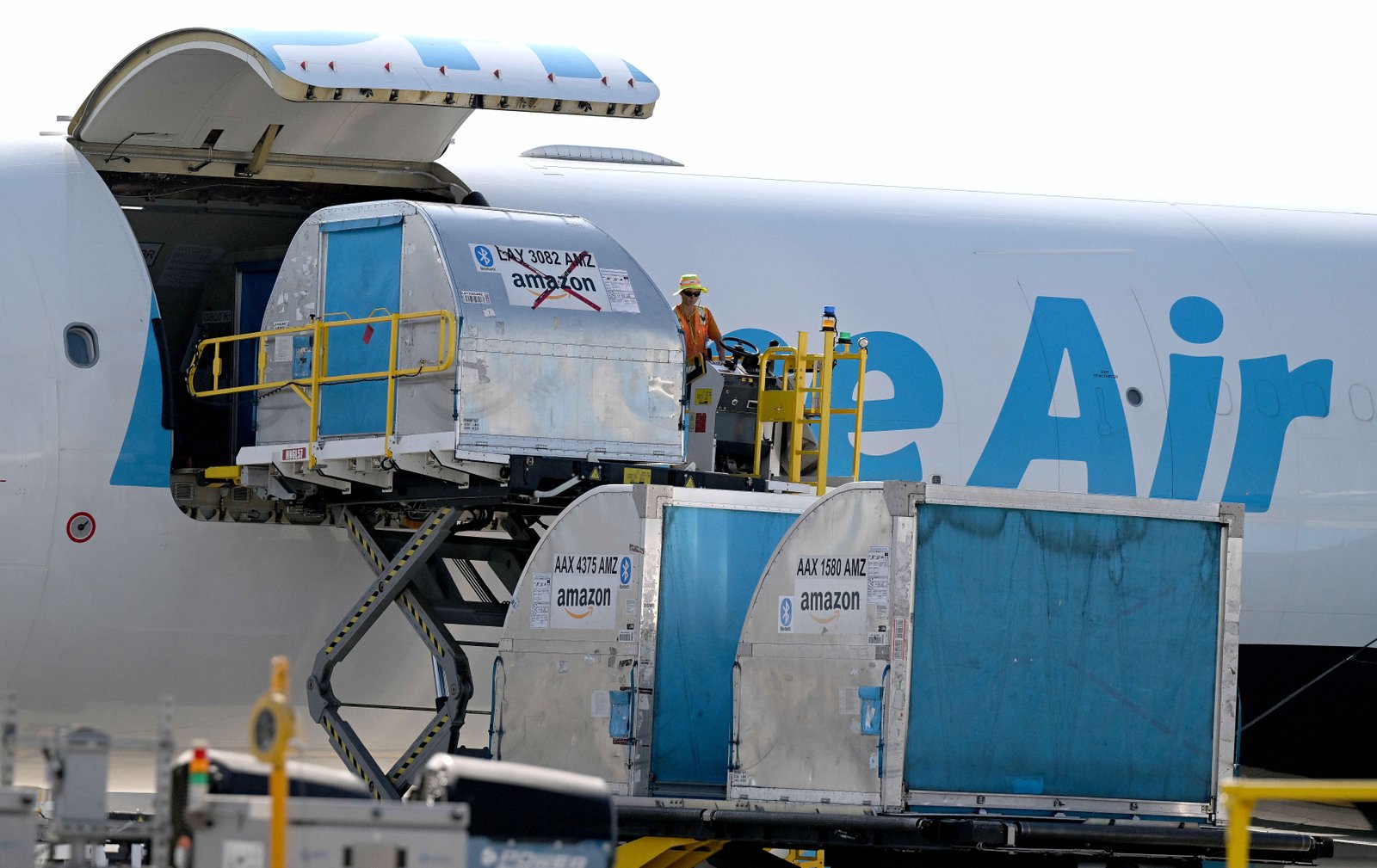 Amazon workers unload containers of packages Tuesday, July 23, 2024,...