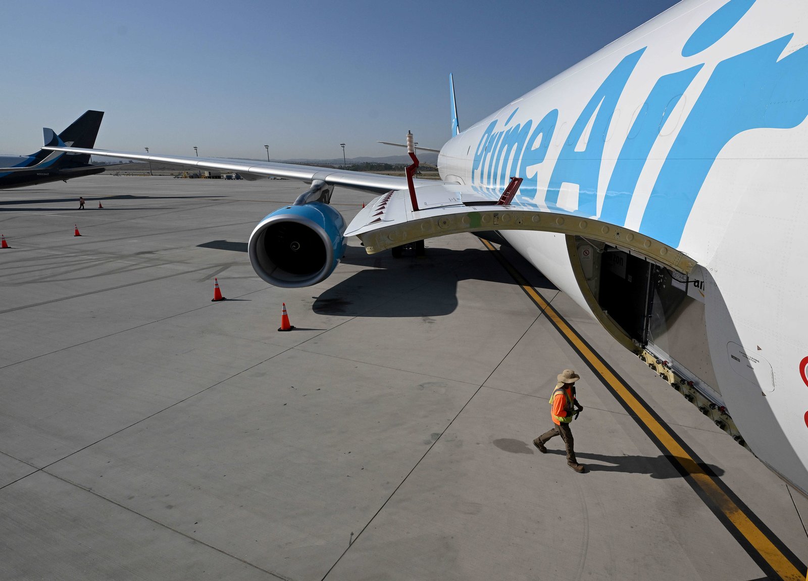 An Amazon employee walks under an Airbus A330 being loaded...