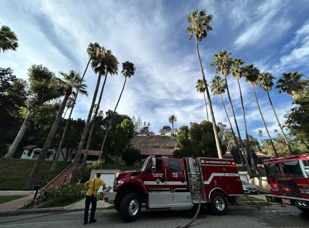 A firefighter watches from Edgehill Road as firefighters put out...