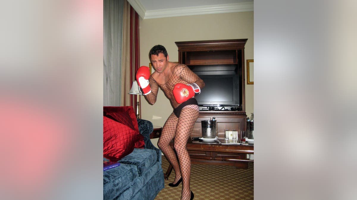 Oscar de la Hoya wearing fishnets and high heels along with his boxing gloves in a Philadelphia hotel room 