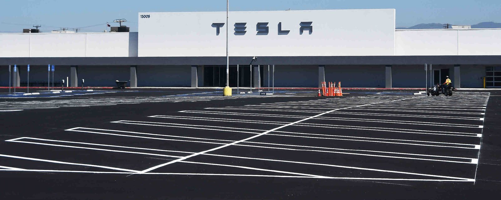 Worker put the fishing touches on the new Tesla center...